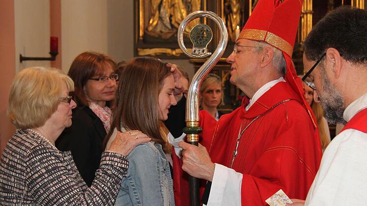 Erzbischof Ludwig Schick zeichnet den Firmlingen mit Chrisamöl das Kreuz auf die Stirn. Foto: Sonny Adam