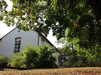 Die Auferstehungskirche in Münnerstadt liegt idyllisch eingebettet und fast ein bisschen versteckt zwischen Bäumen und Büschen.  Foto: Heike Beudert