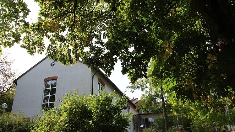 Die Auferstehungskirche in Münnerstadt liegt idyllisch eingebettet und fast ein bisschen versteckt zwischen Bäumen und Büschen.  Foto: Heike Beudert