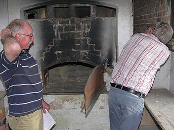 Da zweifelt jemand: Während Herwig Schmidt (links) über die Kosten der Sanierung des Herrether Backhauses grübelt, betrachtet Jürgen Alt den Zustand des Ofens.  Foto: Berthold Köhler