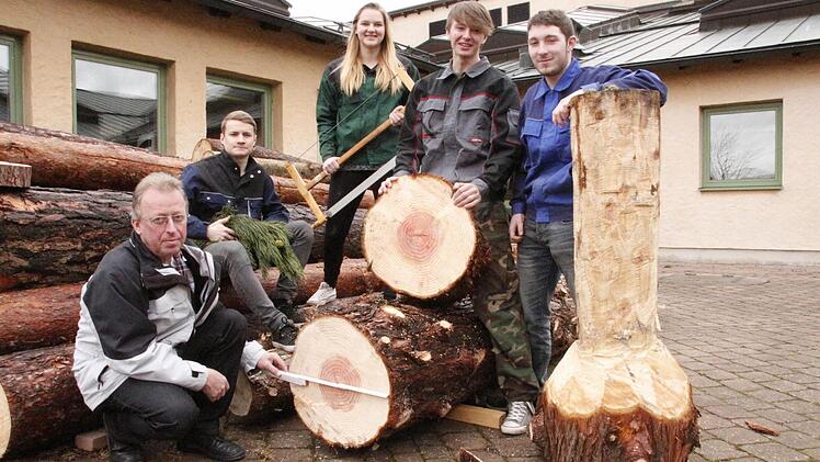 Berufsschullehrer Helmut Taut und seine Schüler Michael Olrich, Franziska Weber, Philipp Huber und Lukas Hof haben den Stamm zersägt. Foto: Josef Hofbauer
