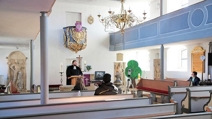 Gottesdienst vor leeren Bänken, aber mit vielen interessierten Followern auf YouTube: Heilgersdorfs Pfarrer Tobias Knötig blickte am Sonntag nicht in die Gesichter von Gläubigen, sondern in die Kamera. Lediglich zwei Techniker und Bürgermeister Maximilian Neeb waren noch in der Kirche. Foto: Bettina Knauth