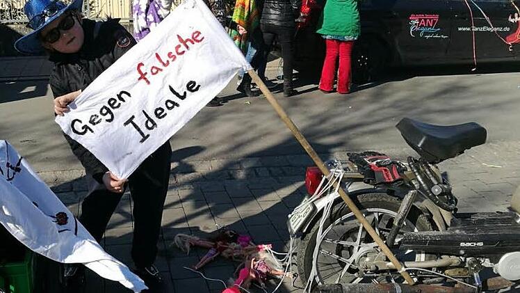 Ein Mitglied des Vereins Rollsport Freunde Forchheim präsentiert kurz vor dem Start des Umzuges eine Seite des Banners. Zum Ärgernis wurden dann aber die Rückseite des Banners und die hinter dem Mofa hergeschleiften Barbiepuppen. Foto: Rollsport-Freunde Forchheim