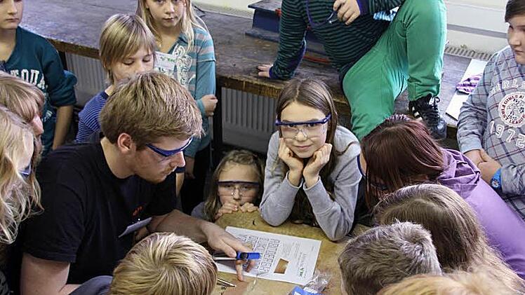 Felix Bauer führt das Löten vor, was Frederike  und Leonie (Bildmitte) besonders fasziniert. Fotos: Ralf Kestel