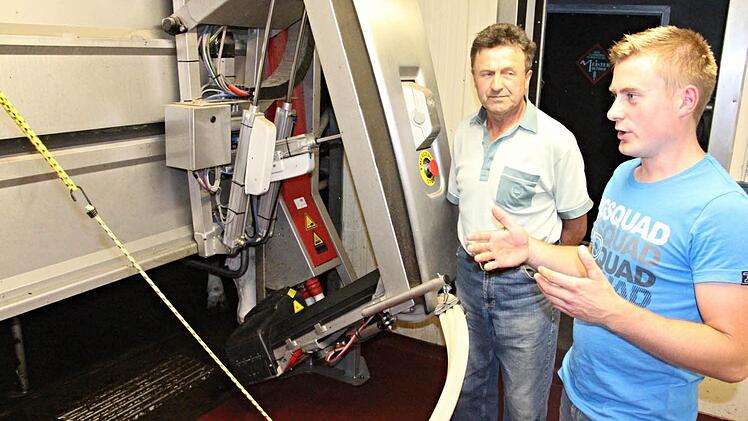 Reinhold und Christian Deringer (von links) Im Herzstück des automatischen Melksystems Foto: Helmut Will