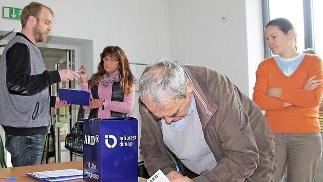 Christoph Popp (links) versuchte mit freundlichen Ansprachen die W&auml;hler zur freiwilligen Teilnahme an der Umfrage f&uuml;r die ARD-Hochrechnung zu gewinnen. In diesem Fall war er sogar doppelt erfolgreich. Viele winkten aber nur ab oder huschten vorbei. Foto: Ralf Kestel