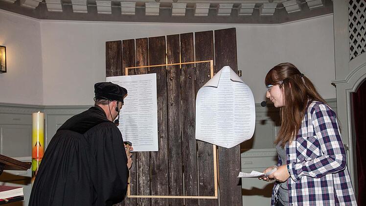 Luther (Michael Heràn) nagelt die Thesen der Dekanatsjugend im Beisein von Luci Herold an die symbolische Tür. Foto: Klaus Gagel