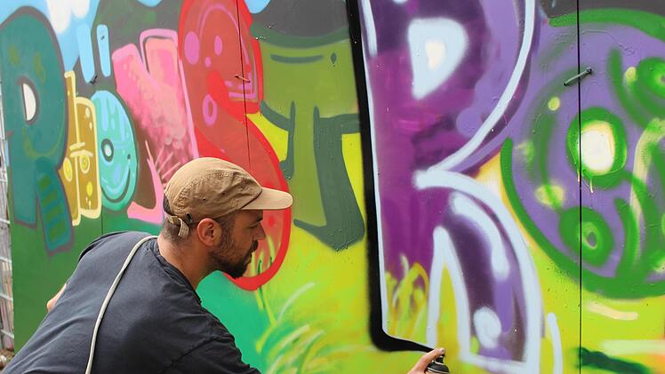 Künstler Philipp Katzenberger bei den Feinarbeiten  für das Kindergarten-Graffiti. Foto: Julia Raab