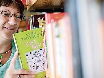 Das Buch, das Elisabeth Broszat hier gerade verräumt, ist einer der wenigen Ausleih-Hits in der Eltmanner Pfarrbibliothek.  Foto: Hendrik Steffens
