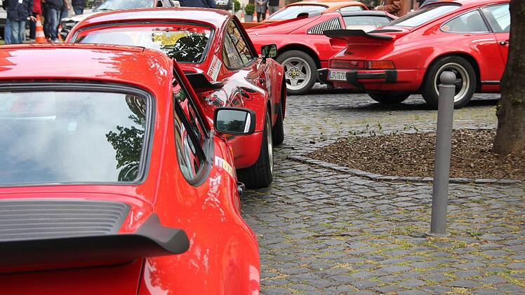 Echte Sportwagen müssen knallrot sein: drei Porsche und ein Ferrari und dahinter noch ein orangefarbener Porsche.