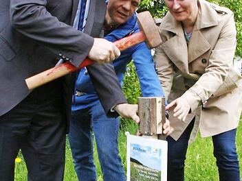 Ein Schild soll auf die besondere Bedeutung der Fläche hinweisen. Assistiert von Bürgermeisterin Christiane Meyer (rechts) und Axel Schauder rammt Landrat Ulm (links) das Schild in den Boden.  Foto: Josef Hofbauer