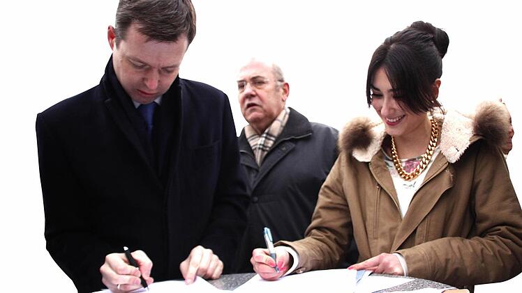 Thomas Silberhorn (CSU-MdB) und die Berufsschülerin Hilal Polat tragen sich in die Unterschriftenliste ,,Pro-S-Bahn-Halt Forchheim Nord'' ein. Im Hintergrund der CSU-Landtagsabgeordnete Eduard Nöth.