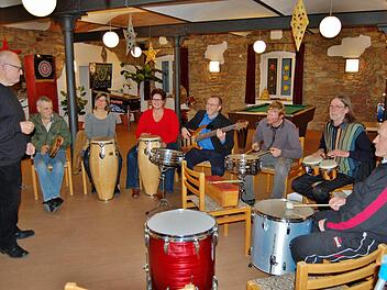 Werner Rieck (stehend), der Leiter der Kissinger Musikwerkstatt, mit den Bewohnern und Betreuern des Simonshofes bei der Probe für das weihnachtliche Konzert am Sonntag, im Kursaal von Bad Bocklet. Foto: Sigismund von Dobschütz