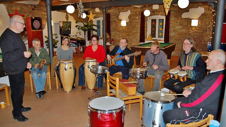 Werner Rieck (stehend), der Leiter der Kissinger Musikwerkstatt, mit den Bewohnern und Betreuern des Simonshofes bei der Probe für das weihnachtliche Konzert am Sonntag, im Kursaal von Bad Bocklet. Foto: Sigismund von Dobschütz