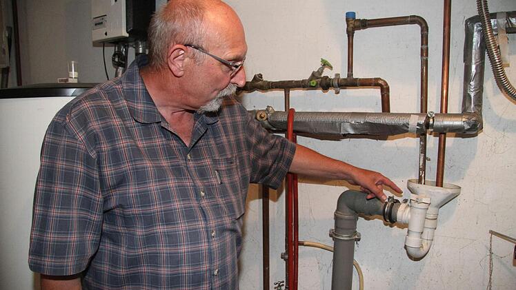 Herrmann Kastner zeigt, dass er schon vor dem Hochwasser Rückstausicherungen eingebaut hatte. Foto: Sonny Adam