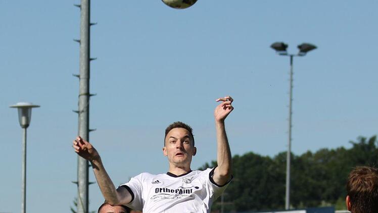 Philipp Nagengast steigt vor dem Adelsdorfer Sebastian Wölfel zum Kopfball hoch.