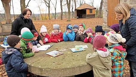 Direkt vor der Wallburg hörten die Buben und Mädchen des Kindergartens Weisbrunn am Vorlesetag Rittergeschichten mit ihren Erzieherinnen Simone Zier (links) und Luise Weinholz (rechts). Foto: Günther Geiling