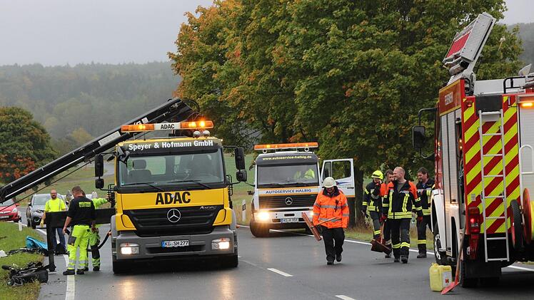 Aufräumarbeiten an der Unfallstelle: Die Feuerwehr Oberthulba reinigt die Straße, mehrere Abschleppwagen sind vor Ort. Foto: Benedikt Borst