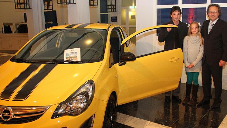 Hauptgewinner Stefan Schmidt mit seinem Opel Corsa sowie Sofia und Matthias Seidler. Foto: Barbara Herbst