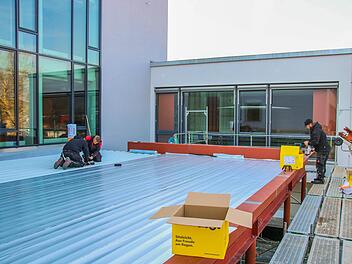 Die Arbeiter der Firma Münster aus Kulmbach sind dabei, die Dampfsperre über dem Eingangsbereich zu verlegen. Foto: Jürgen Gärtner