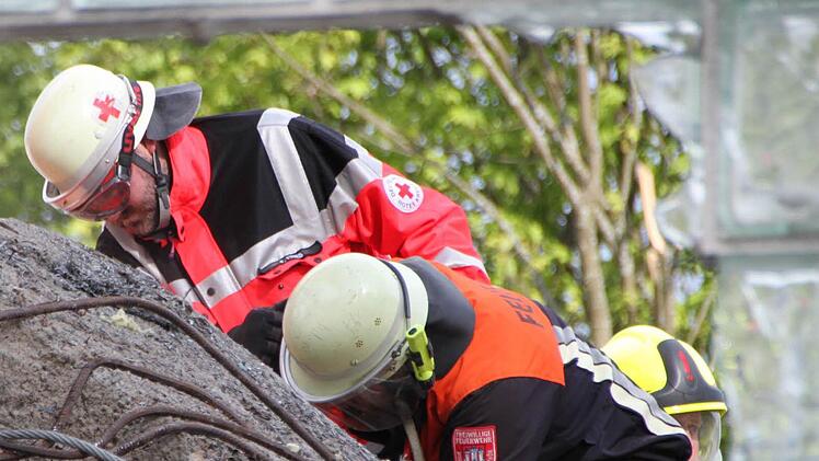 Ein großes Betonteil ist auf den Bagger gestürzt. Die Rettungskräfte kommen nicht an den Baggerfahrer heran. Foto: Ulrike Müller