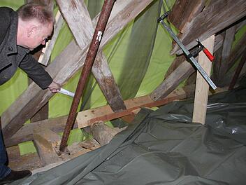 Bürgermeister Helmut Blank zeigt auf Dachbereiche, die notgesichert wurden, damit der Dachstuhl neue Stabilität erhält. Foto: Heike Beudert