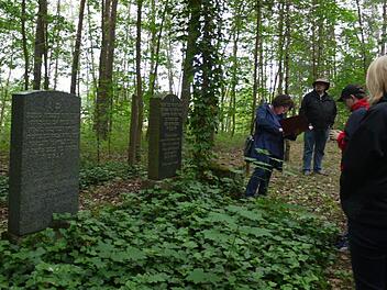 Christiane Kolbet (l.) steht vor dem Grabstein von Ludwig Wassermann, dem letzten, der auf dem Judenfriedhof gesetzt wurde. Foto: Pauline Lindner