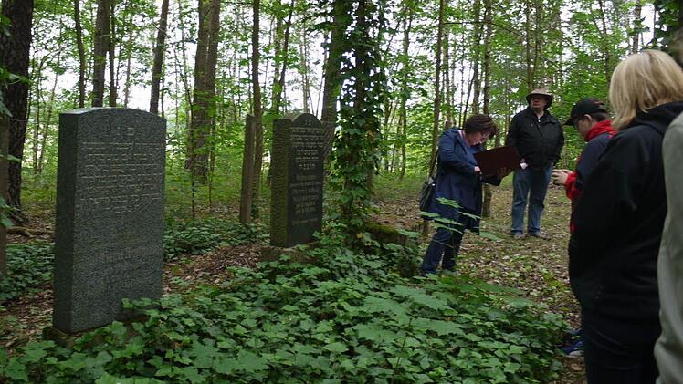Christiane Kolbet (l.) steht vor dem Grabstein von Ludwig Wassermann, dem letzten, der auf dem Judenfriedhof gesetzt wurde. Foto: Pauline Lindner