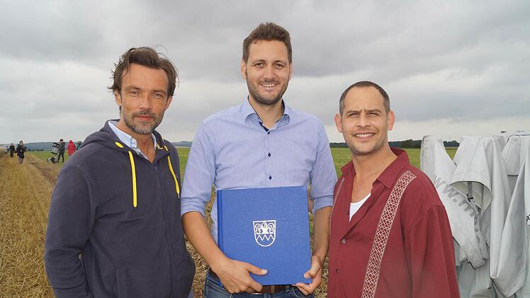 Beim Dreh für "Lommbock": Die Hauptdarsteller Lucas Gregorowicz (links) und Moritz Bleibtreu mit Kirchheims Bürgermeister Björn Jungbauer (Mitte) und dem Gästebuch der Gemeinde.  Foto: Gemeinde Kirchheim
