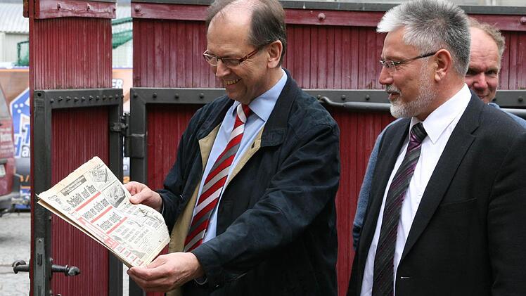 Pfarrer Hans Reeg und Bürgermeister Josef Mend schauen sich die schon fast historische Schlagzeile an. Foto: Daniela Röllinger