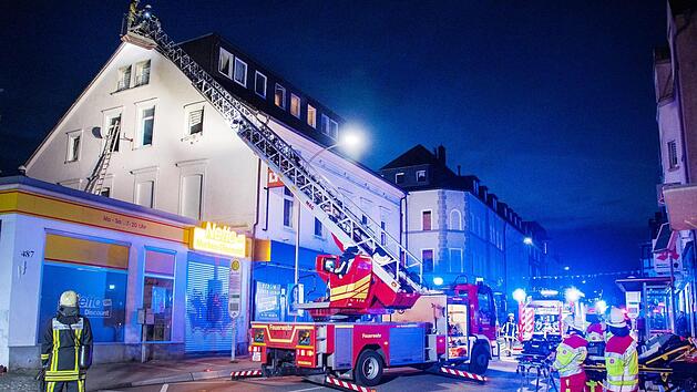 Einsatzkr&auml;fte der Feuerwehr stehen vor einem Haus in Bochum. Die Feuerwehr hat am Freitag 16 Menschen mit Drehleitern aus einem brennenden Haus in Bochum gerettet. Zehn von ihnen, darunter eine Schwangere, h&auml;tten bei dem Brand am fr&uuml;hen Morgen eine Rauchvergiftung erlitten, teilte die Feuerwehr mit. Foto: Simon Heussen/Feuerwehr Bochum /dpa