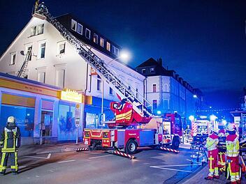 Einsatzkräfte der Feuerwehr stehen vor einem Haus in Bochum. Die Feuerwehr hat am Freitag 16 Menschen mit Drehleitern aus einem brennenden Haus in Bochum gerettet. Zehn von ihnen, darunter eine Schwangere, hätten bei dem Brand am frühen Morgen eine Rauchvergiftung erlitten, teilte die Feuerwehr mit. Foto: Simon Heussen/Feuerwehr Bochum /dpa