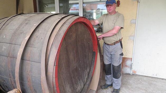 Mitarbeiter Robert Tremel mit einem Reparatur-Auftrag: Dieses 2000-Liter-Fass muss überholt und die Eisenreifen nachgezogen werden. Fotos: Monika Schütz