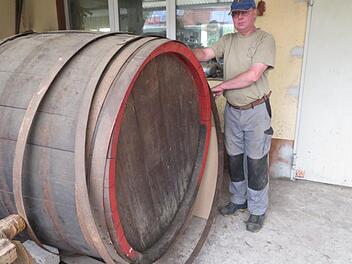 Mitarbeiter Robert Tremel mit einem Reparatur-Auftrag: Dieses 2000-Liter-Fass muss überholt und die Eisenreifen nachgezogen werden. Fotos: Monika Schütz