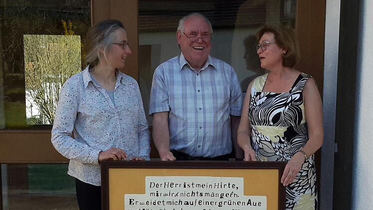 Der Psalm 23 als filigrane Laubsägearbeit: Arnim Waldau (Mitte) überreichte an Pfarrerin Daniele Roth (links) und die Vertrauensfrau der evangelischen Kirchengemeinde Wildflecken, Christine Gehrlein, ein ganz besonderes Objekt.Rolf Pralle
