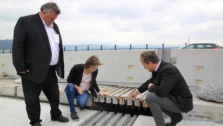 Die Brücken-Übergangskonstruktion wird erneuert. Das "Klack-klack"-Geräusch, das verursacht wird, wenn Lkw auf die Brücke fahren, soll so minimiert werden. Von links: Bürgermeister Gerhard Schneider, MdB Emmi Zeulner und Thomas Pfeifer von der Autobahndirektion.
