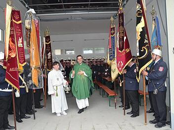 Höhepunkt der Feierlichkeiten war die Segenshandlung im neuen Feuerwehrgerätehaus durch Dekan Detlef Pötzl, flankiert von Fahnenabordnungen mehrerer Feuerwehren. Fotos: K.- H. Hofmann