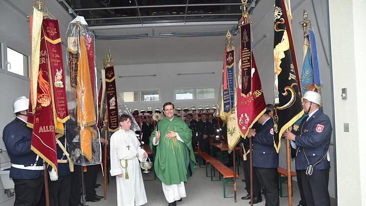 Höhepunkt der Feierlichkeiten war die Segenshandlung im neuen Feuerwehrgerätehaus durch Dekan Detlef Pötzl, flankiert von Fahnenabordnungen mehrerer Feuerwehren. Fotos: K.- H. Hofmann