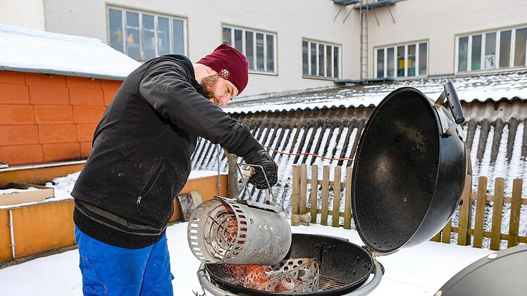 Mit einem Anschürkamin erzeugt Oliver Kopp die Glut.  Foto:  Matthias Hoch