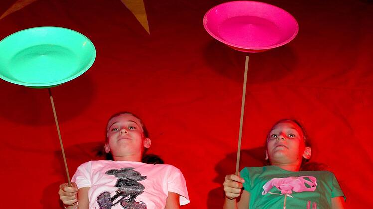 Luise (10 Jahre, links) und Emily (9) lassen am Boden liegend Teller kreisen.  Fotos: Ralf Naumann