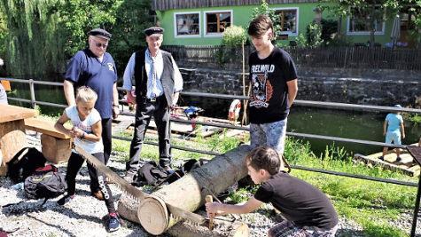 Beschwerlich ist das Sägen von Baumscheiben mit der Ziehsäge. Aufmerksame Beobachter sind (von links) Vorsitzender Georg Geiger, Daniel Schüler und Nico Querfurth.