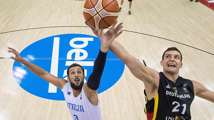 Deutschlands Paul Zipser (rechts) wird von Italiens Marco Belinelli (links) in der Luft attackiert. Foto: Lukas Schulze/dpa