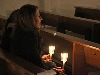 Friedenslichter verbreiten in der halbdunklen Kirche in Unterpreppach ihr weiches Licht.