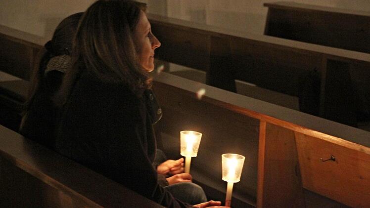 Friedenslichter verbreiten in der halbdunklen Kirche in Unterpreppach ihr weiches Licht.