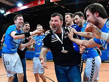 Jonas Thümmler, Oliver Heß und Torhüter Jan Stochl (von rechts) feiern mit Trainer Robert Andersson und ihren Teamkollegen die Rückkehr in die Handball-Bundesliga. Fotos: Sportfoto Zink
