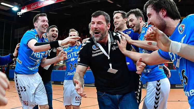 Jonas Thümmler, Oliver Heß und Torhüter Jan Stochl (von rechts) feiern mit Trainer Robert Andersson und ihren Teamkollegen die Rückkehr in die Handball-Bundesliga. Fotos: Sportfoto Zink
