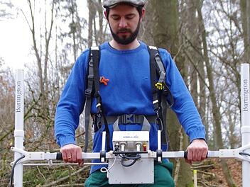 Der Archäologe Philipp Schinkel sucht nach Abweichungen im Magnetfeld, die Indizien für Straßen oder Gebäude unter dem Waldboden sein können. Foto: Marco Meißner