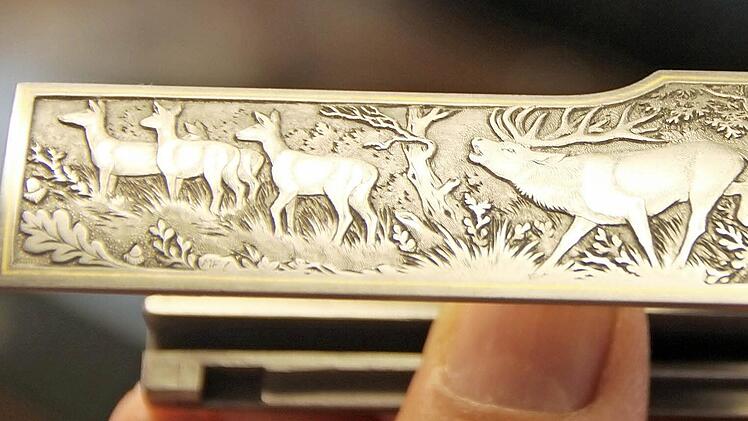 Hirsch und Eichenlaub in einer klassischen Waldszene sind typische Motive, die eine Jagdwaffe des hochpreisigen Segments schmücken können.