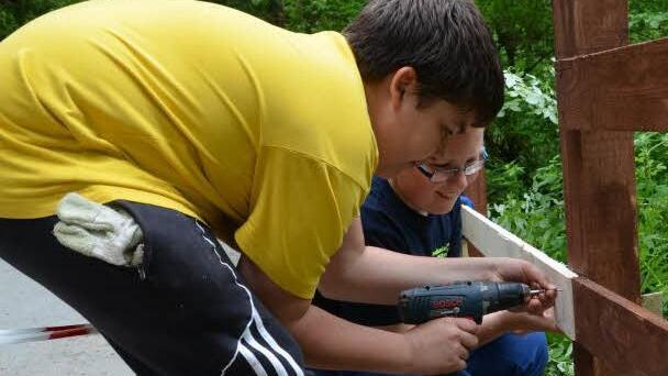 Die Jugend des THW Kronach erneuerte den Holzzaun im Stübental: Daniel Cazacu (links) und Lars Richter beim Anschrauben der Bretter. Fotos: Medienprojekt KJ Wallenfels