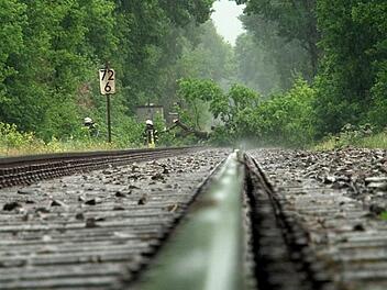 Niedersachsen, Osnabrück: Einsatzkräfte der Feuerwehr entfernen umgestürzte Bäume von Bahngleisen. Ein heftiges Unwetter hat für eine Sperrung der Bahnstrecke zwischen Osnabrück und Oldenburg gesorgt. Foto: -/Nord-West-Media TV/dpa